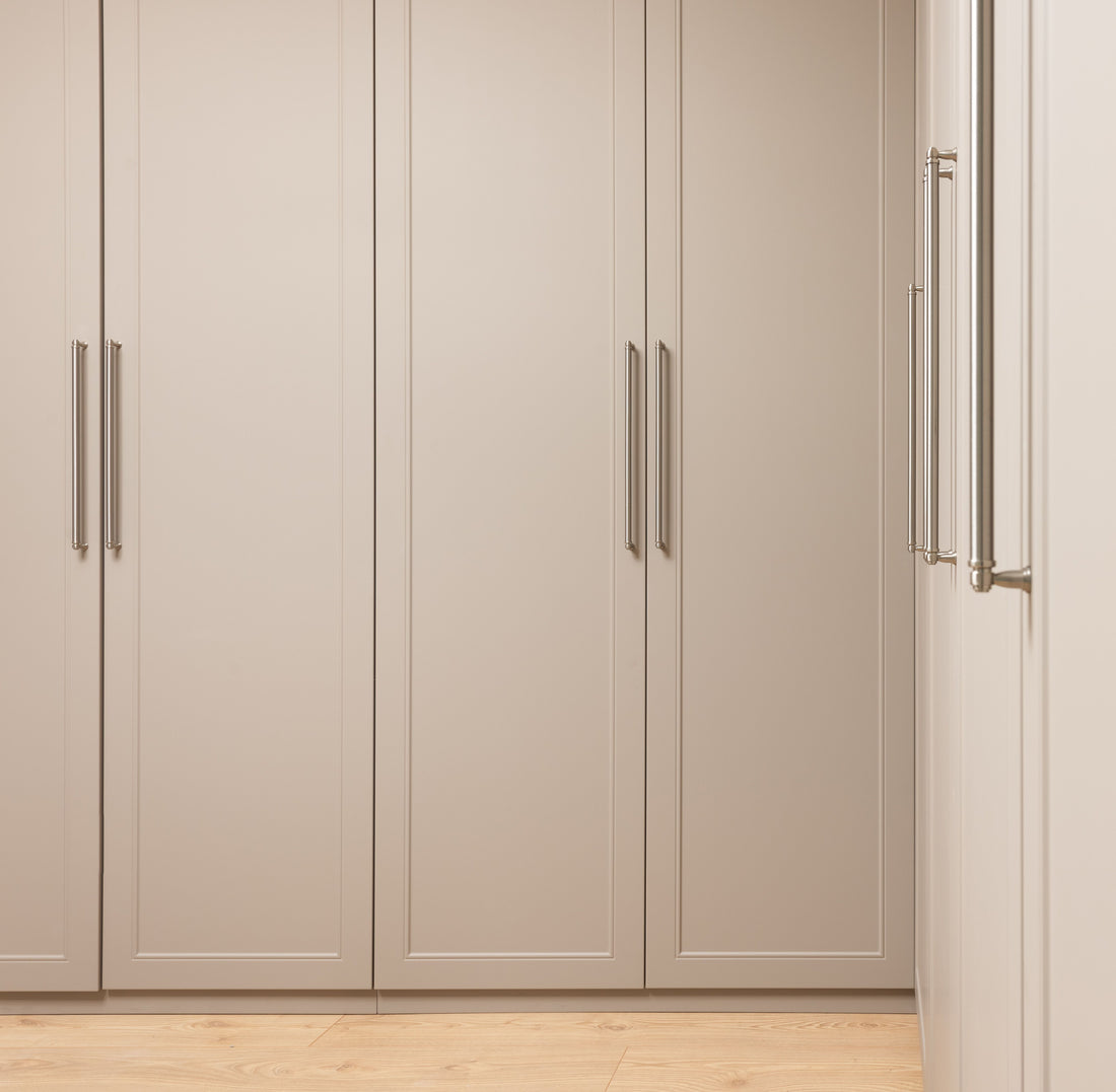Slim built-in cabinet doors with brushed nickel handles in a neutral hallway